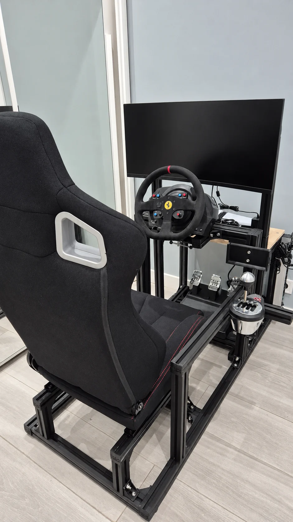 Setup real de cliente NaM GT con cockpit negro, volante, pedales y soporte de shifter